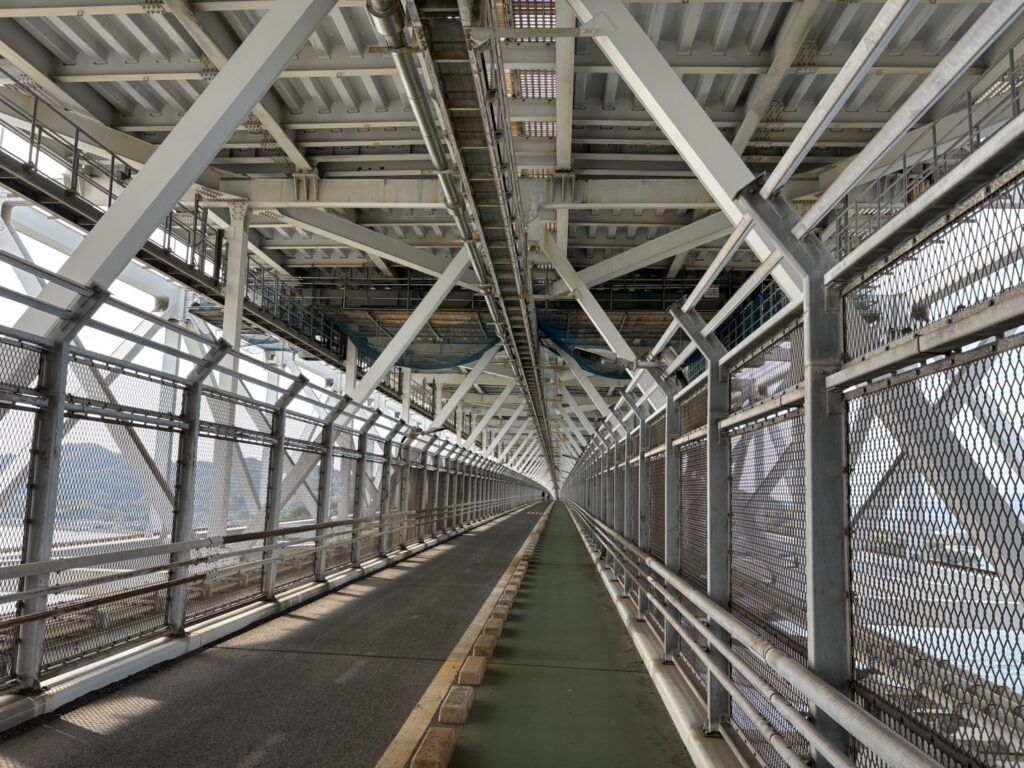 因島大橋の自転車道を走行中に見える海とメッシュフェンス越しの景色