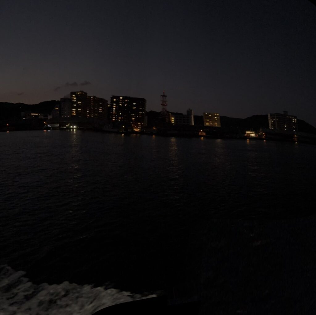 ラズリ船上から撮影した夜の尾道港と街の灯りが映る海の風景